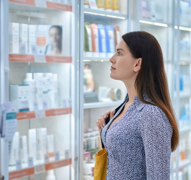 In a drugstore. Female customer choosing products in a drugstore